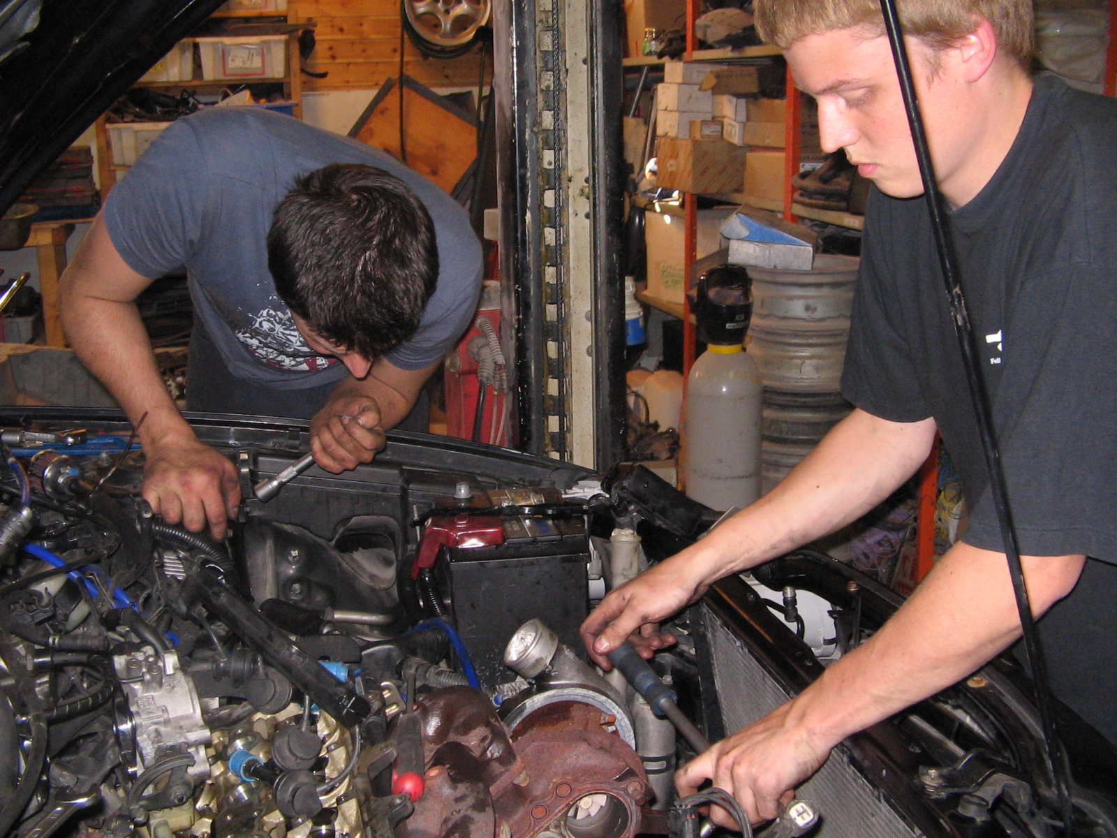 Hjelperne mine...Kim og Ronny...
<br />Her ser dere ronny driver og skru av eksosmaninfoilen og turboen...faen ka vi plagdes der......et godt råd...ta av radiatoren...blir straks mere plass og holde på...