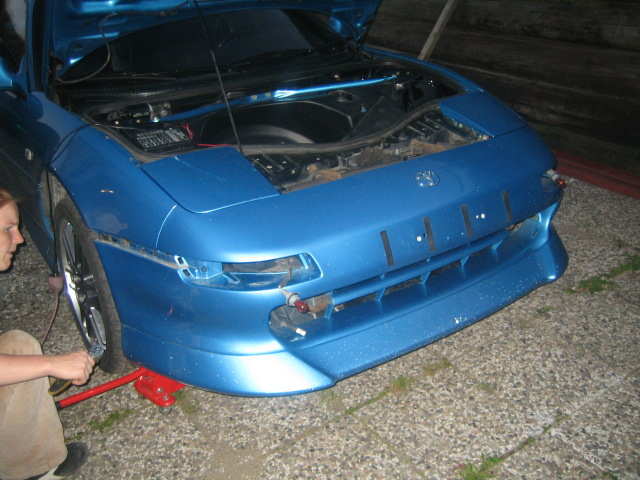 I skjøten mellom framskjermen og fronten sitter det to bolter utrolig vrient til, så etter litt gransking kom jeg frem til at jeg skulle prøve å ta de fra undersiden, bilen skal opp (og det er jo et prosjekt i seg selv siden bilen er lav nok)