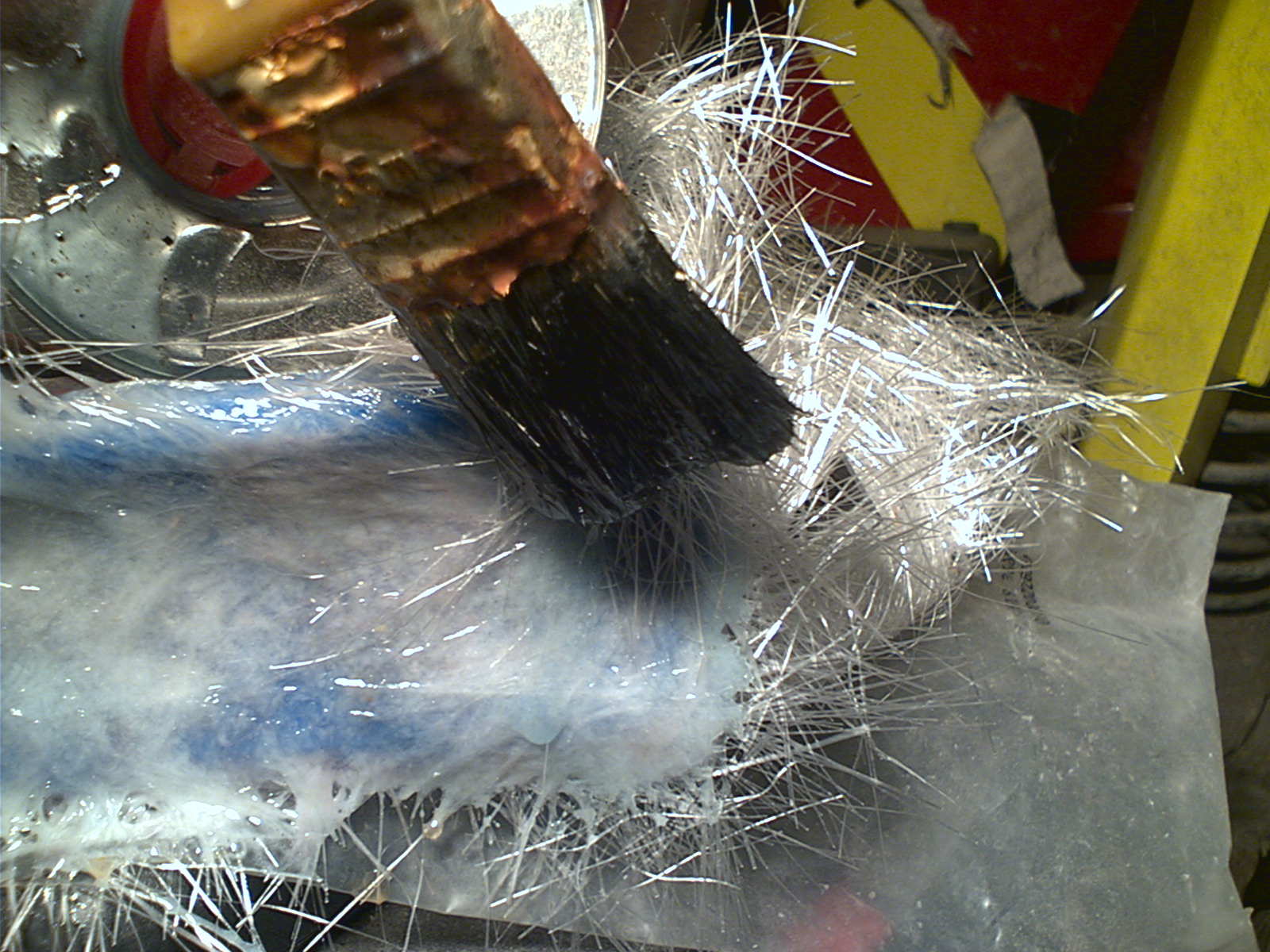 Legger på glassfiber, og smører på en blanding av polyester og herder for å få det til å stivne. Dette blir steinhardt!