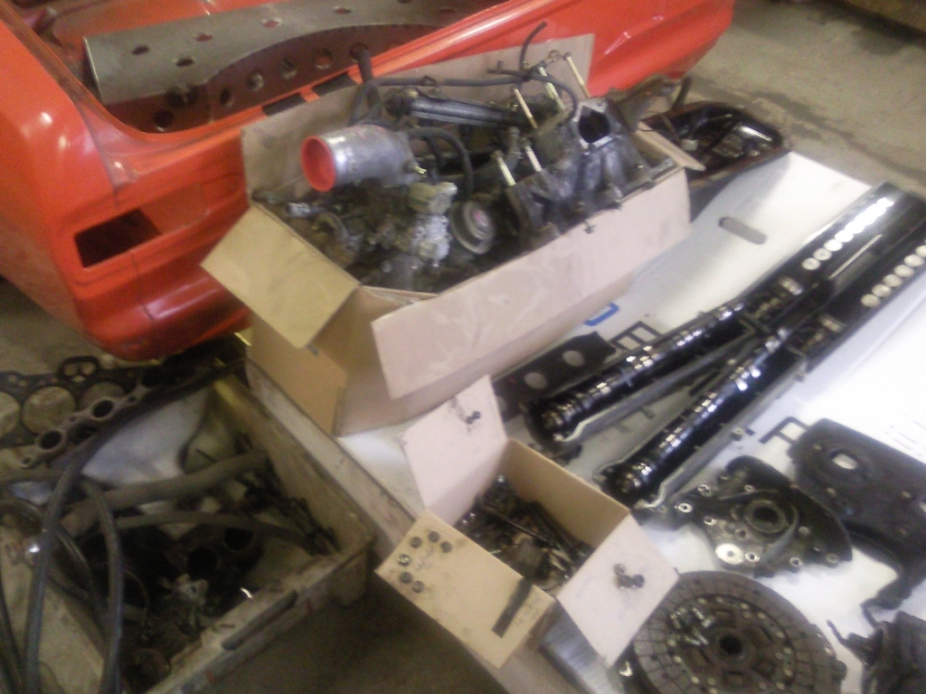 En haug med deler.. Komplett kompressor med alle tilhørende deler vil bli solgt..  Legg merke til den oransje Escorten Mk1 som står bak. Original BDA som bygges opp etter Rallyspec fra Ford.. Inkl avkjølt bakaksel med pumpe, rør og kjøler!!